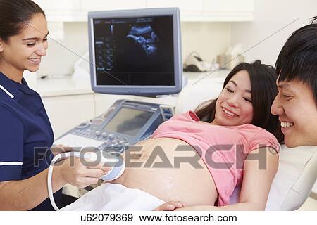 Stock Photo - Pregnant Woman And Partner Having 4D Ultrasound Scan. Fotosearch