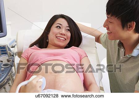 Pregnant Woman And Partner Having 4D Ultrasound Scan View Large Photo Image Stock Photo - Pregnant Woman And Partner Having 4D Ultrasound Scan. Fotosearch