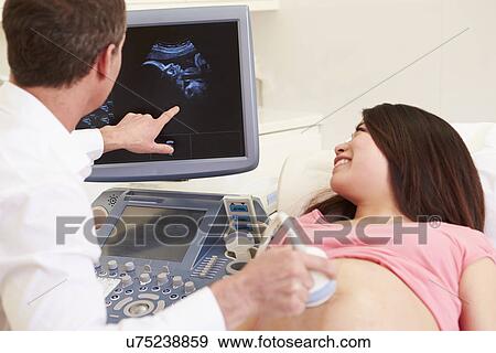 Stock Photo - Pregnant Woman And Partner Having 4D Ultrasound Scan. Fotosearch