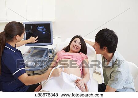 Pregnant Woman And Partner Having 4D Ultrasound Scan View Large Photo Image Stock Photo - Pregnant Woman And Partner Having 4D Ultrasound Scan. Fotosearch