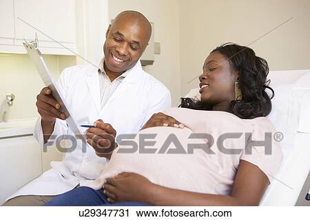 Stock Image - Pregnant Woman Being Given Ante Natal Check By Doctor. Fotosearch