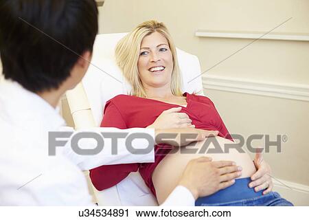 Stock Image - Pregnant Woman Being Given Ante Natal Check By Doctor. Fotosearch