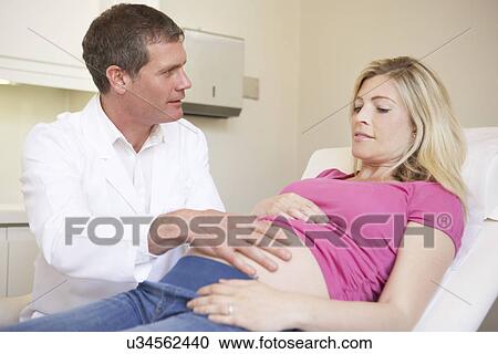 Stock Image - Pregnant Woman Being Given Ante Natal Check By Doctor. Fotosearch