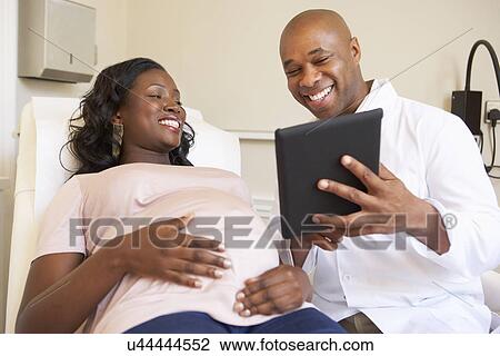 Stock Image - Pregnant Woman Being Given Ante Natal Check By Doctor. Fotosearch