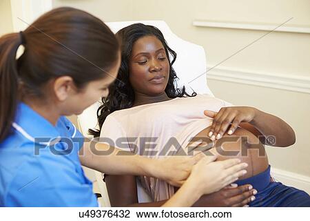 Stock Image - Pregnant Woman Being Given Ante Natal Check By Doctor. Fotosearch