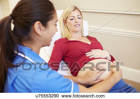 Stock Image - Pregnant Woman Being Given Ante Natal Check By Nurse. Fotosearch