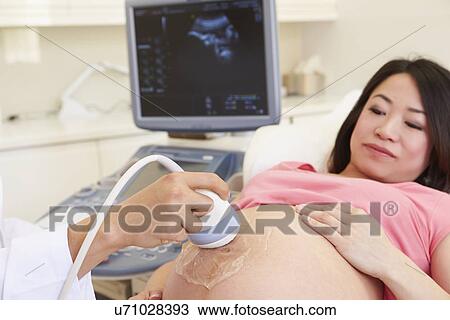 Stock Image - Pregnant Woman Having 4D Ultrasound Scan. Fotosearch