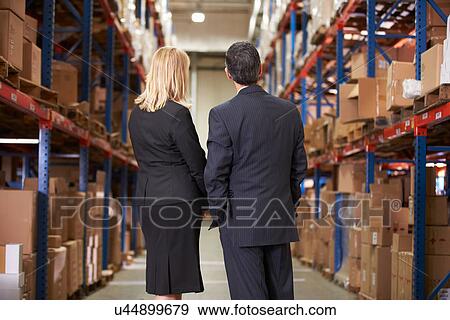 Rear View Of Businesswoman And Businessman In Warehouse View Large Photo Image Stock Photo - Rear View Of Businesswoman And Businessman In Warehouse. Fotosearch