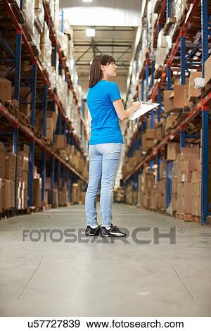 Stock Photo - Rear View Of Female Worker In Distribution Warehouse. Fotosearch