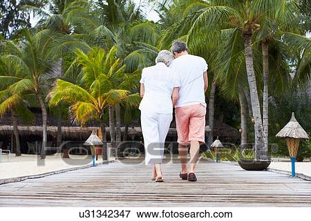 Rear View Of Senior Couple Walking On Wooden Jetty View Large Photo Image Stock Photo - Rear View Of Senior Couple Walking On Wooden Jetty. Fotosearch