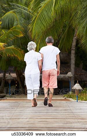 Rear View Of Senior Couple Walking On Wooden Jetty View Large Photo Image Stock Photo - Rear View Of Senior Couple Walking On Wooden Jetty. Fotosearch