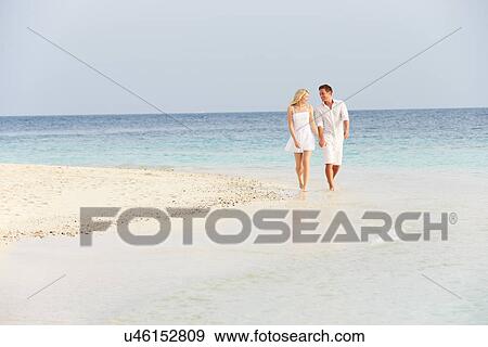 Stock Photo - Romantic Couple Walking On Beautiful Tropical Beach. Fotosearch