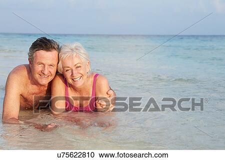 Romantic Senior Couple Lying In Sea On Beach Holiday View Large Photo Image Stock Image - Romantic Senior Couple Lying In Sea On Beach Holiday. Fotosearch