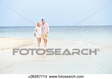 Romantic Senior Couple Walking On Beautiful Tropical Beach View Large Photo Image Picture - Romantic Senior Couple Walking On Beautiful Tropical Beach. Fotosearch