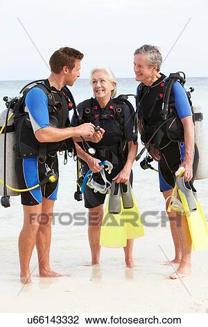 Stock Image - Senior Couple Having Scuba Diving Lesson With Instructor. Fotosearch