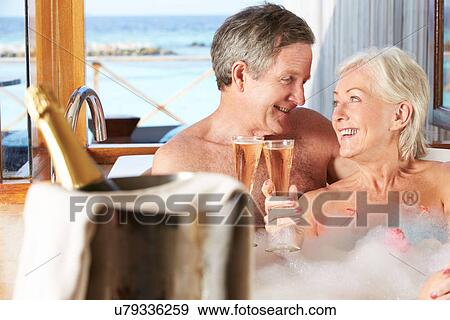 Stock Photo - Senior Couple Relaxing In Bath Drinking Champagne Together. Fotosearch