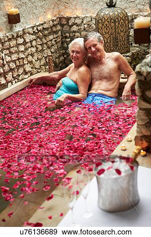 Stock Photo - Senior Couple Relaxing In Flower Petal Covered Pool At Spa. Fotosearch