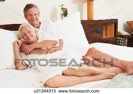 Senior Couple Relaxing In Hotel Room Wearing Robes View Large Photo Image Stock Photography - Senior Couple Relaxing In Hotel Room Wearing Robes. Fotosearch