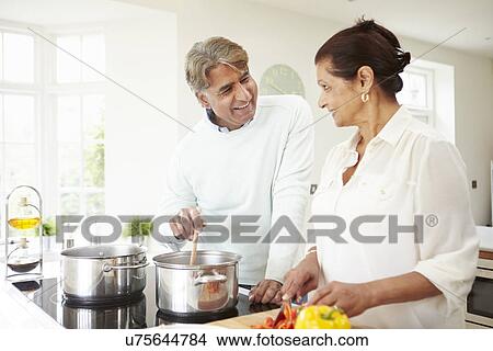 Picture - Senior Indian Couple Cooking Meal At Home. Fotosearch