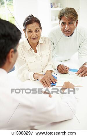 Stock Photo - Senior Indian Couple Meeting With Financial Advisor At Home. Fotosearch