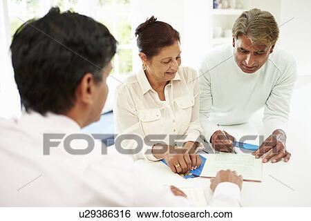 Stock Photograph - Senior Indian Couple Meeting With Financial Advisor At Home. Fotosearch