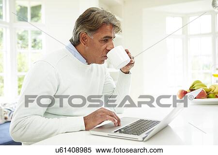 Stock Photography - Senior Indian Man Using Laptop At Home. Fotosearch