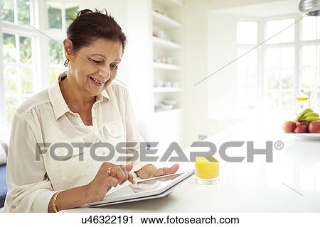 Senior Indian Woman Using Digital Tablet At Home View Large Photo Image Stock Image - Senior Indian Woman Using Digital Tablet At Home. Fotosearch