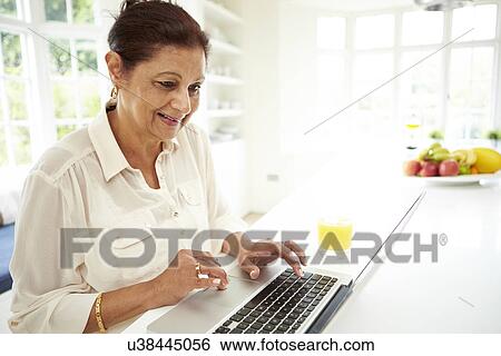 Senior Indian Woman Using Laptop At Home View Large Photo Image Stock Photograph - Senior Indian Woman Using Laptop At Home. Fotosearch