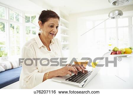 Senior Indian Woman Using Laptop Whilst Eating Breakfast View Large Photo Image Stock Photograph - Senior Indian Woman Using Laptop Whilst Eating Breakfast. Fotosearch