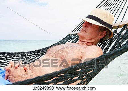 Stock Image - Senior Man Relaxing In Beach Hammock . Fotosearch
