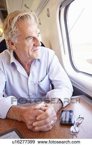 Stock Photo - Senior Man Relaxing On Train Journey. Fotosearch