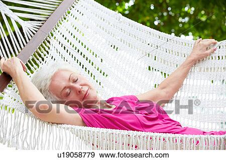 Stock Photo - Senior Woman Relaxing In Beach Hammock. Fotosearch