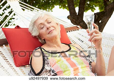 Senior Woman Relaxing In Beach Hammock With Champagne View Large Photo Image Stock Photo - Senior Woman Relaxing In Beach Hammock With Champagne. Fotosearch