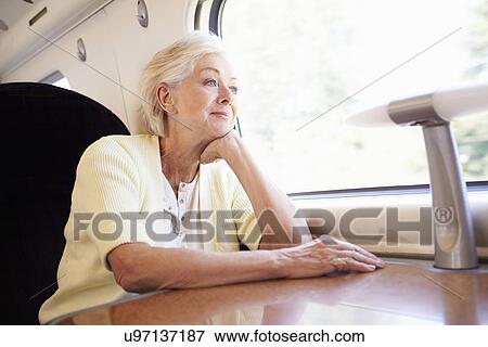 Stock Photo - Senior Woman Relaxing On Train Journey. Fotosearch