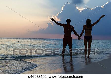 Silhouette Of Couple Walking Along Beach At Sunset View Large Photo Image Stock Image - Silhouette Of Couple Walking Along Beach At Sunset. Fotosearch