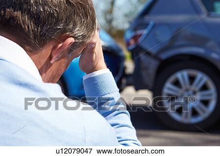 Stock Photo - Stressed Driver Sitting At Roadside After Traffic Accident. Fotosearch