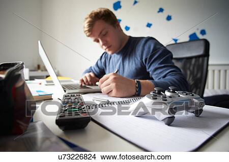 Picture - Teenage Boy Using Digital Tablet And Mobile Phone In Bedroom. Fotosearch