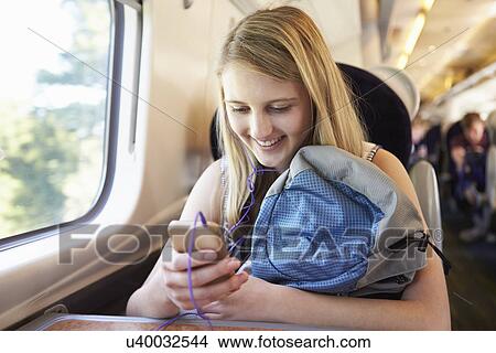 Picture - Teenage Girl Listening To Music On Train Journey. Fotosearch