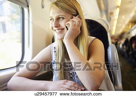 Stock Photo - Teenage Girl Using Mobile Phone On Train Journey. Fotosearch