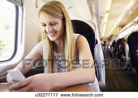 Teenage Girl Using Mobile Phone On Train Journey View Large Photo Image Stock Photo - Teenage Girl Using Mobile Phone On Train Journey. Fotosearch
