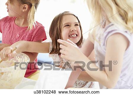 Stock Photo - Three Girls Making Cupcakes In Kitchen. Fotosearch