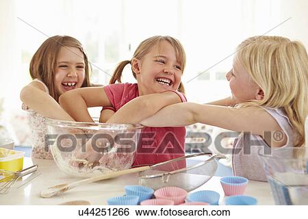 Stock Photograph - Three Girls Making Cupcakes In Kitchen. Fotosearch