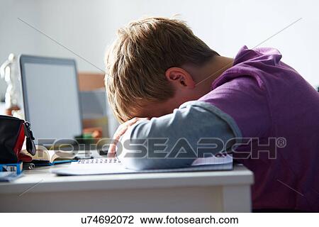 Stock Image - Tired Boy Studying In Bedroom. Fotosearch
