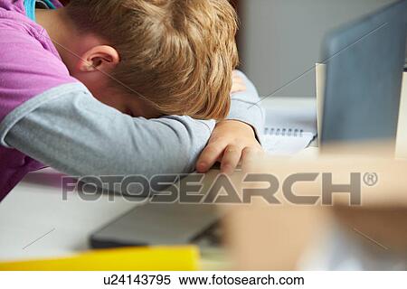 Stock Photography - Tired Boy Studying In Bedroom. Fotosearch