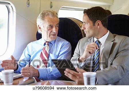 Two Businessmen Having Meeting On Train View Large Photo Image Picture - Two Businessmen Having Meeting On Train. Fotosearch