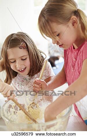 Stock Photo - Two Girls Making Cupcakes In Kitchen. Fotosearch