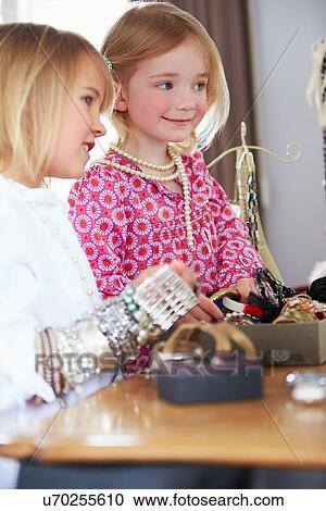 Stock Image - Two Girls Playing With Jewelry And Make Up. Fotosearch