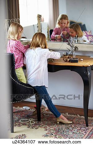 Stock Photo - Two Girls Playing With Jewelry And Make Up. Fotosearch