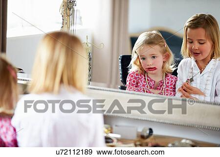 Stock Photo - Two Girls Playing With Jewelry And Make Up. Fotosearch