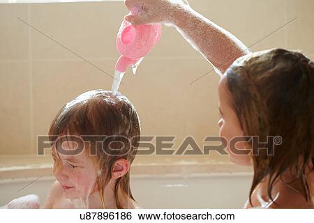 Stock Photograph - Two Girls Sharing Bubble Bath And Washing Hair. Fotosearch